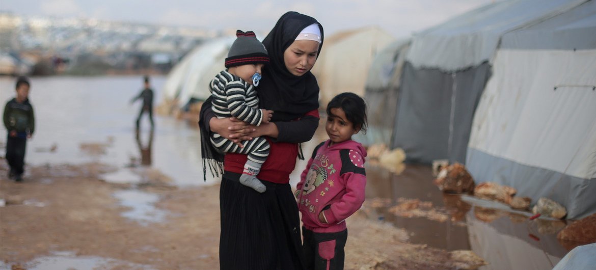 Unos niños están fuera de su tienda de campaña tras las inundaciones sufridas en enero de 2019 en el campamento de Kafr Losin, en el noroeste de Siria.